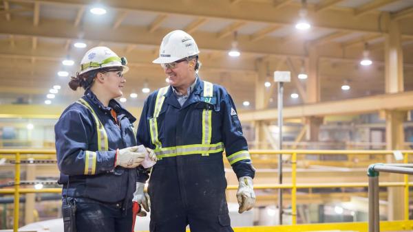 Two people talking in safety gear 